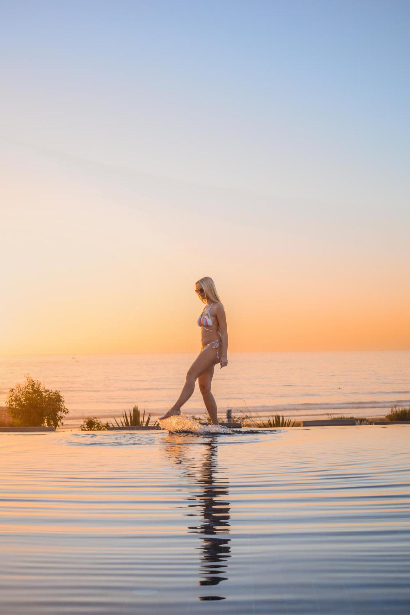 Hotel Hyatt Regency Taghazout Esterno foto A woman walking on a skimboard